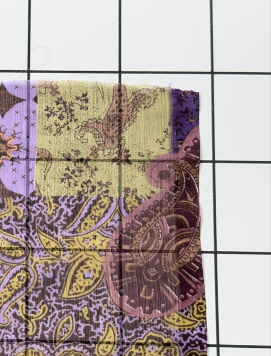 Patchwork fabric with purple and yellow patterns on a white background