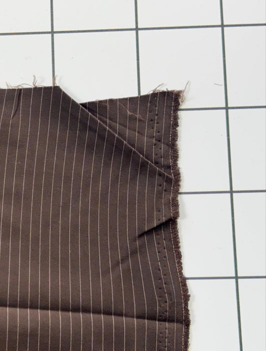 Brown fabric with white pinstripes on a grid background